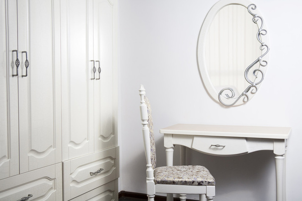 Tavolo bianco, sedia, specchio in stile antico e modernista
 - Foto, immagini
