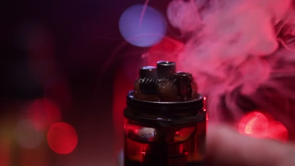 Vape concept. Smoke clouds and vape liquid bottles on dark background. Light effects. Useful as background or vape advertisement or vape background. Selective focus - Footage, Video