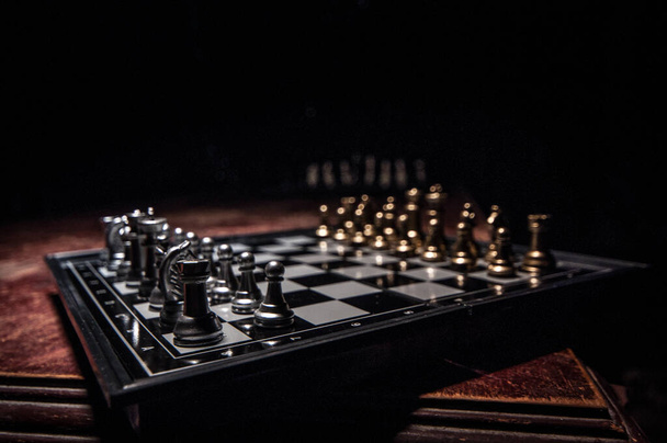 Šachové figurky na tmavém pozadí s kouřem a mlhou. Selektivní zaměření - Fotografie, Obrázek