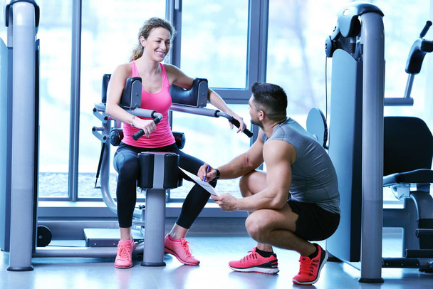 Gym woman exercising with her personal trainer - Photo, image