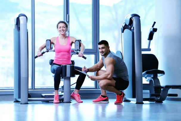 Gym woman exercising with her personal trainer - Valokuva, kuva
