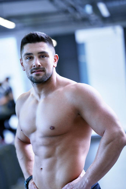 Strong handsome man exercising at the gym - Foto, afbeelding