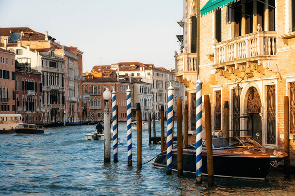 イタリア、ヴェネツィア、グランドキャナル沿いの木製の係留杭 - 写真・画像