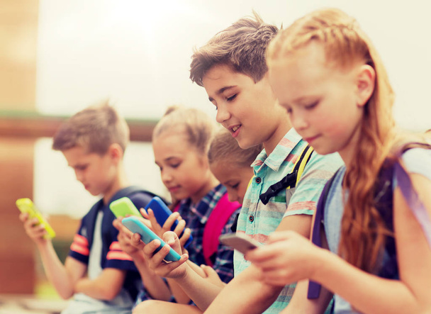 elementary school students with smartphones - Fotoğraf, Görsel