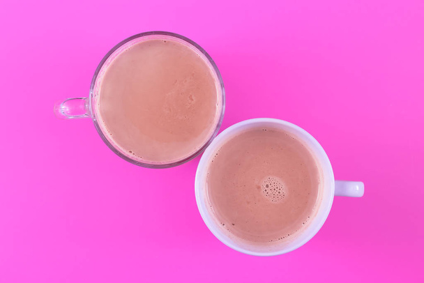 Two Hot cocoa in a glass mug on a colored background in the middle - Фото, зображення