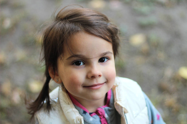 Hymyilevä valkoinen tyttö poninhännät valkoinen liivi
 - Valokuva, kuva