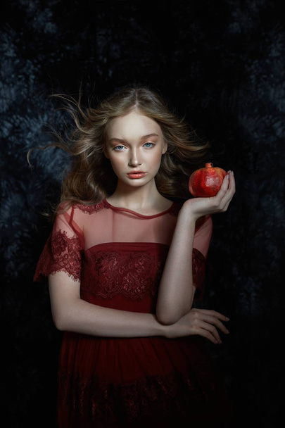 Beautiful blonde girl with pomegranate fruit in her hands. Sprin - Fotoğraf, Görsel