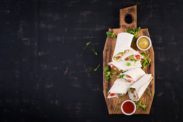Verse tortilla wraps met kip en verse groenten op houten plank. Kipburrito. Mexicaans eten. Gezond voedsel concept. Mexicaanse keuken.Bovenaanzicht, overhead - Foto, afbeelding
