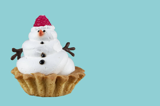 Sneeuwpop Cupcake. Kerst taart op een blauwe achtergrond. - Foto, afbeelding