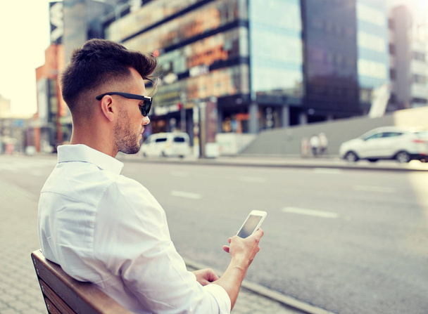 close up of man texting on smartphone in city - Valokuva, kuva