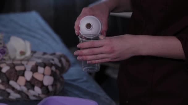 Szakmai kozmetológus nő öntsön oldatot egy szépségszalonban. - Felvétel, videó