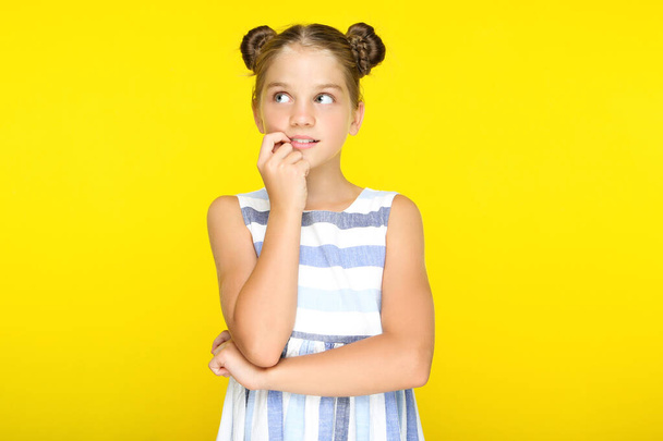 Young beautiful girl thinking on yellow background - Fotó, kép