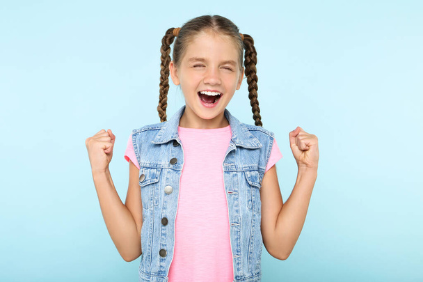 Young happy girl on blue background - Φωτογραφία, εικόνα