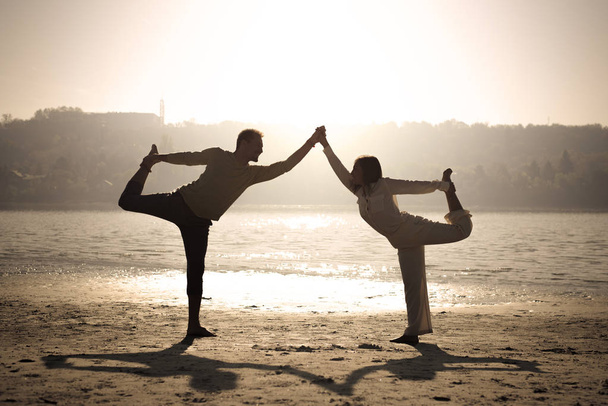 Coppia facendo danza posa yoga sulla spiaggia
 - Foto, immagini