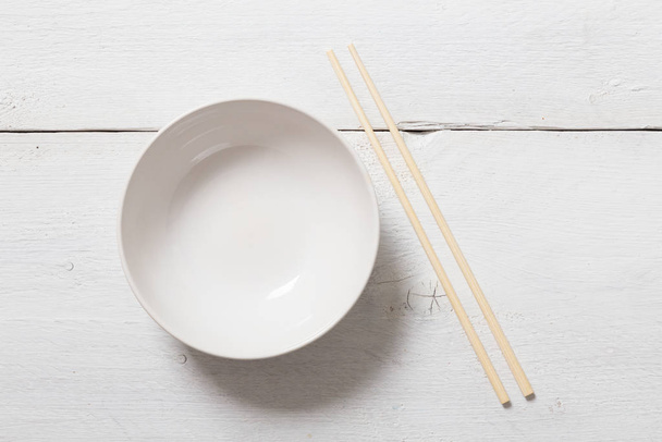 bowl with chopsticks on wood in aerial view. - Foto, Imagem