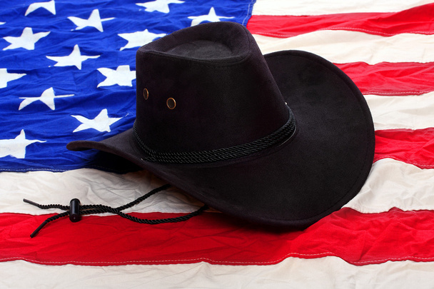 Black leather hat on american flag - Фото, зображення