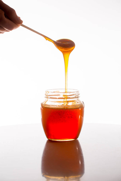 glass of fresh honey on white background - Φωτογραφία, εικόνα