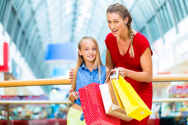 mother and daughter in department store with shopping bags - Фото, зображення