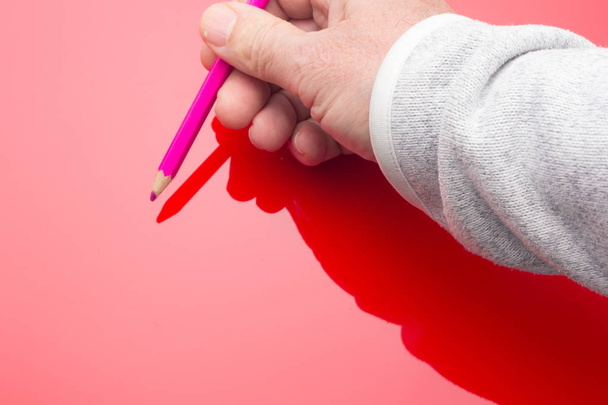 Colored pencil in the hand of an adult person - 写真・画像