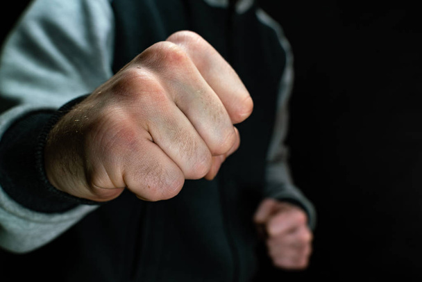 Fist of a man on a dark background close-up - Фото, изображение