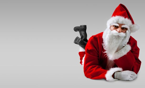 Santa Claus lying down with serious expression - Photo, Image