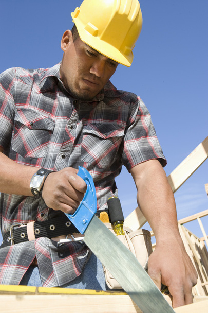 Construction worker sawing - Фото, зображення
