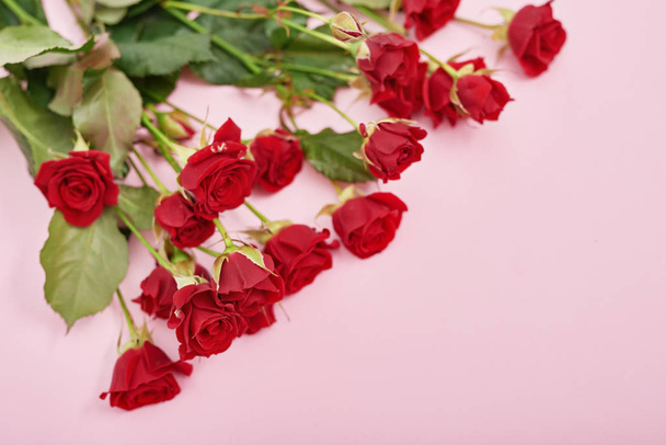 Valentijnsdag romantische achtergrond met hart en bloemen. Valentijnskaart met kopieerruimte. Bloemen rozen op roze achtergrond. Valentijnsdag wenskaart sjabloon 14 februari - Foto, afbeelding