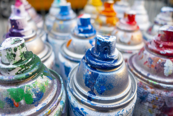 rows of used spray cans with colorful paint markings - Foto, Imagem