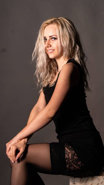 Cute blonde woman in beautiful dress posing in studio - Foto, imagen