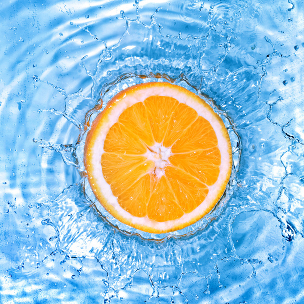 Fresh orange dropped into water with bubbles - Foto, Imagem