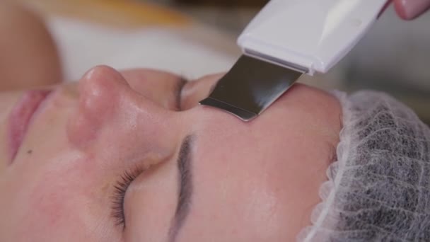 Профессиональный косметолог женщина делает ультразвуковой очистки лица к пациенту. - Кадры, видео