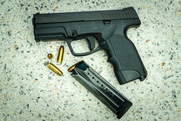 Gun with magazine and ammo on floor - Φωτογραφία, εικόνα