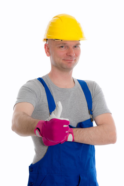 jovem trabalhador com polegar para cima em masmorras azuis e top duro amarelo
 - Foto, Imagem