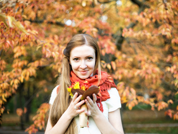 schattig jong meisje in herfst park met bloemen - Foto, afbeelding