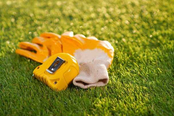 Artificial grass background with protective glooves and measuring tape - Valokuva, kuva