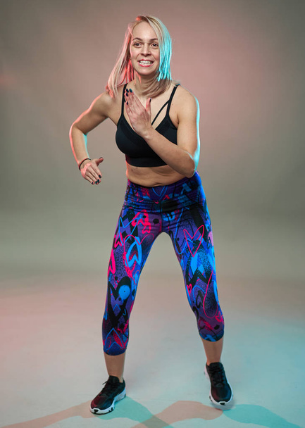 Fitness model doing aerobic exercises and dancing, studio shot - Valokuva, kuva