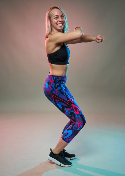 Fitness model doing aerobic exercises and dancing, studio shot - 写真・画像