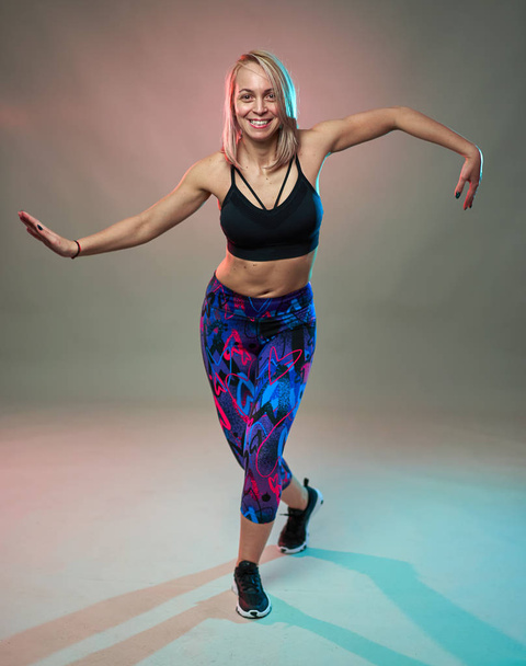 Fitness model doing aerobic exercises and dancing, studio shot - Foto, Imagem