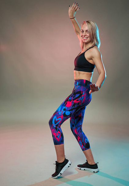 Fitness model doing aerobic exercises and dancing, studio shot - Photo, Image