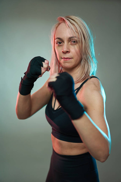 Woman fighter doing shadow boxking with hands wrapped - Фото, зображення