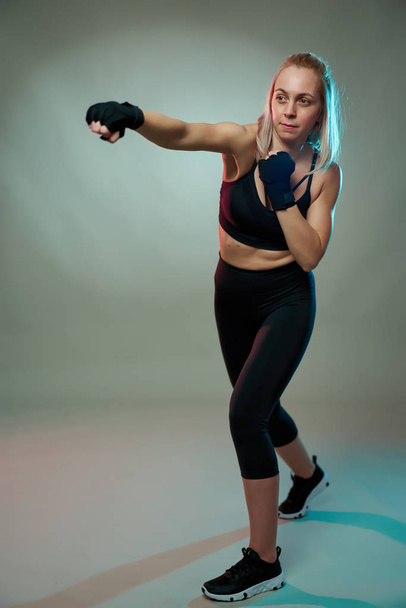 Woman fighter doing shadow boxking with hands wrapped - Foto, imagen
