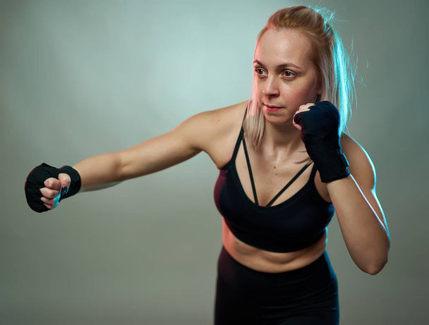 Woman fighter doing shadow boxking with hands wrapped - Фото, зображення