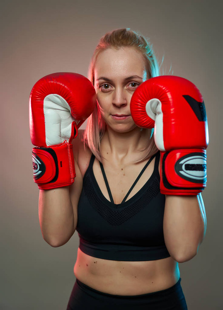 Boxer girl with red gloves training, studio shot - Фото, изображение