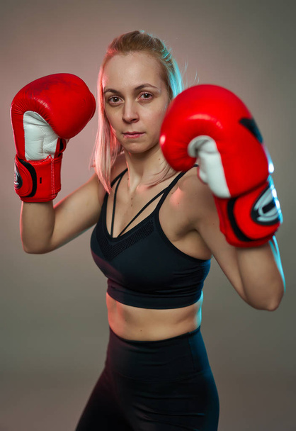 Boxer girl with red gloves training, studio shot - Фото, изображение