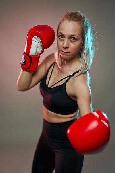 Boxer girl with red gloves training, studio shot - Foto, Imagem