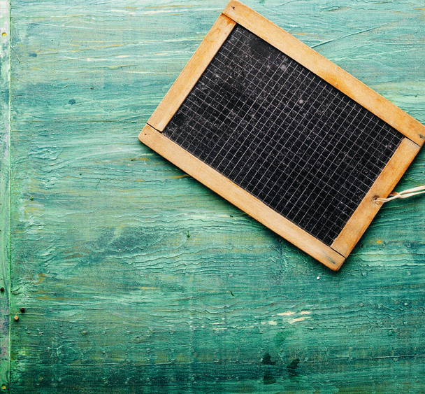 High Angle View of Black Board Marked with Grid Lines on Rustic Green Painted Wooden Surface with Copy Space - Photo, Image