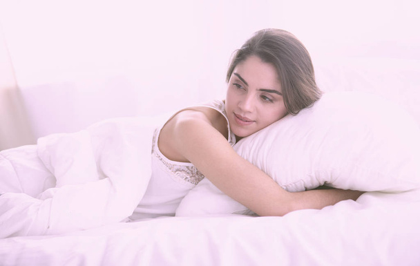 mooie jonge vrouw koesteren in bed in de ochtend. Mooie - Foto, afbeelding