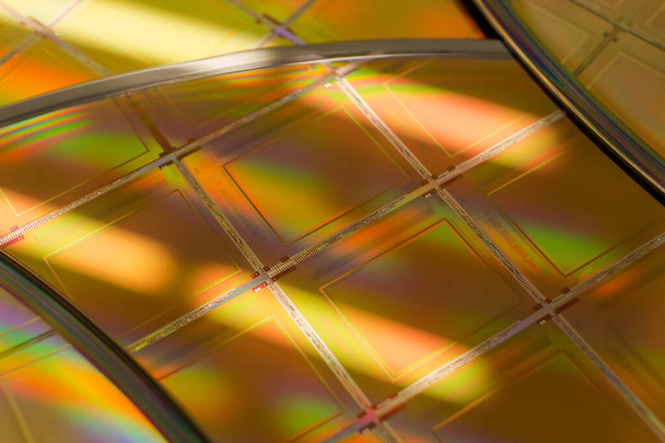 Meerdere siliciumwafers met microchips - Een wafel is een dunne plak halfgeleidermateriaal, zoals een kristallijn silicium, dat wordt gebruikt in elektronica voor de vervaardiging van geïntegreerde schakelingen. - Foto, afbeelding