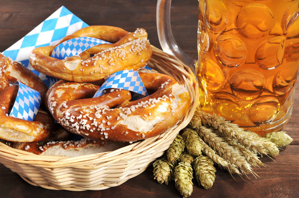 original bavarian brine with salt in a basket on wooden boards and beer\n - Foto, Imagem