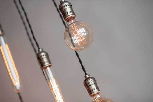 Edison retro žárovky žárovky na šedé omítkové stěny pozadí v podkroví. Koncept Vintage stylu. Kopírovat prostor - Fotografie, Obrázek